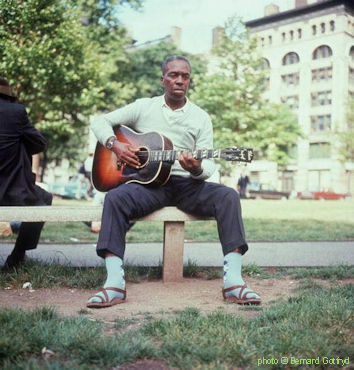 N E H E M I A H   'S K I P'   J A M E S at Washington Square Park (half covert on the left: Mississippi John Hurt); source: https://media.gettyimages.com/photos/american-blues-musician-skip-james-plays-guitar-while-sitting-on-a-picture-id3228571; photographer: Bernard Gotfryd